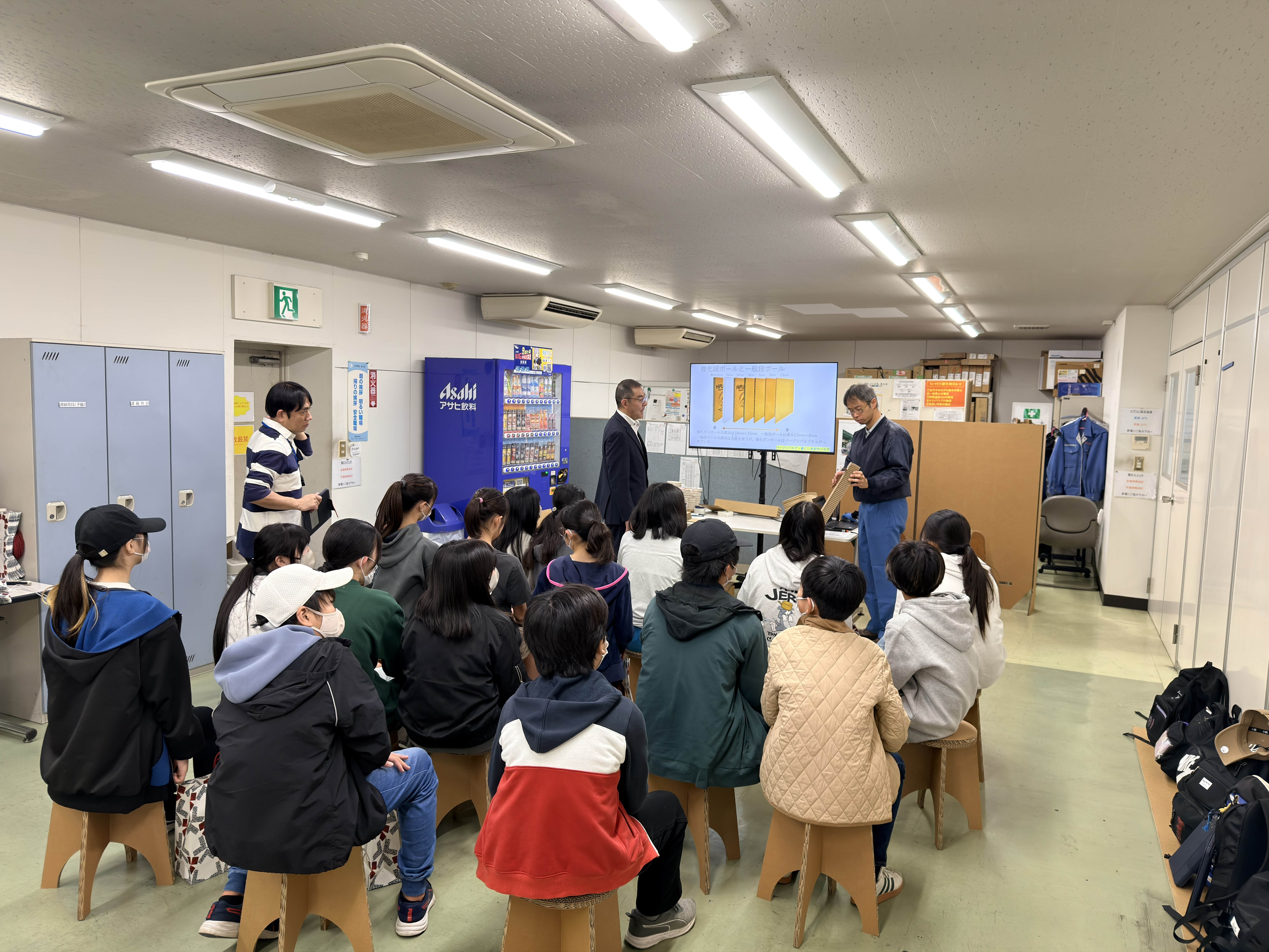 座学で強化ダンボールの説明を聞く児童たち