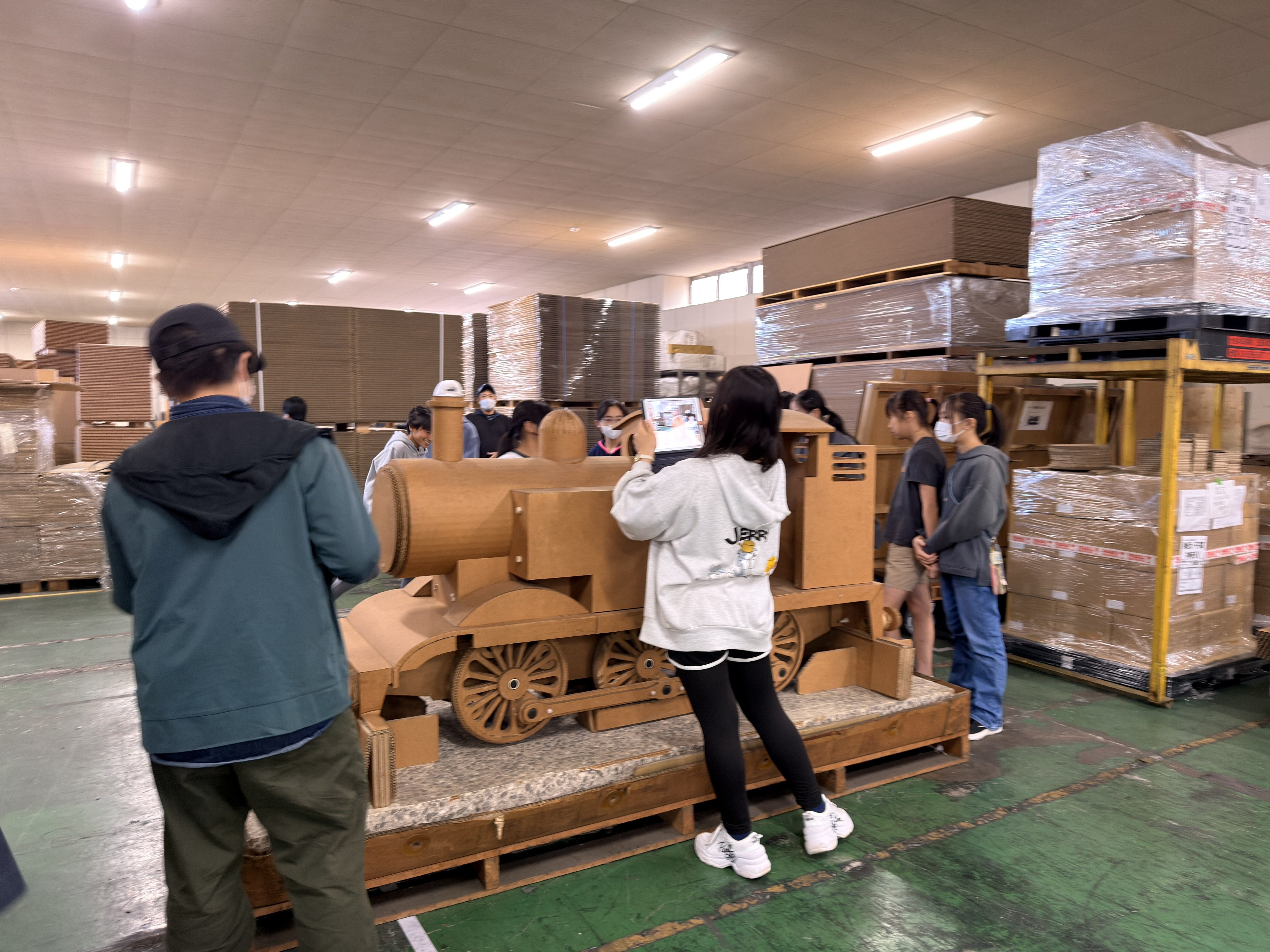 強化ダンボール製の機関車に見入る児童たち